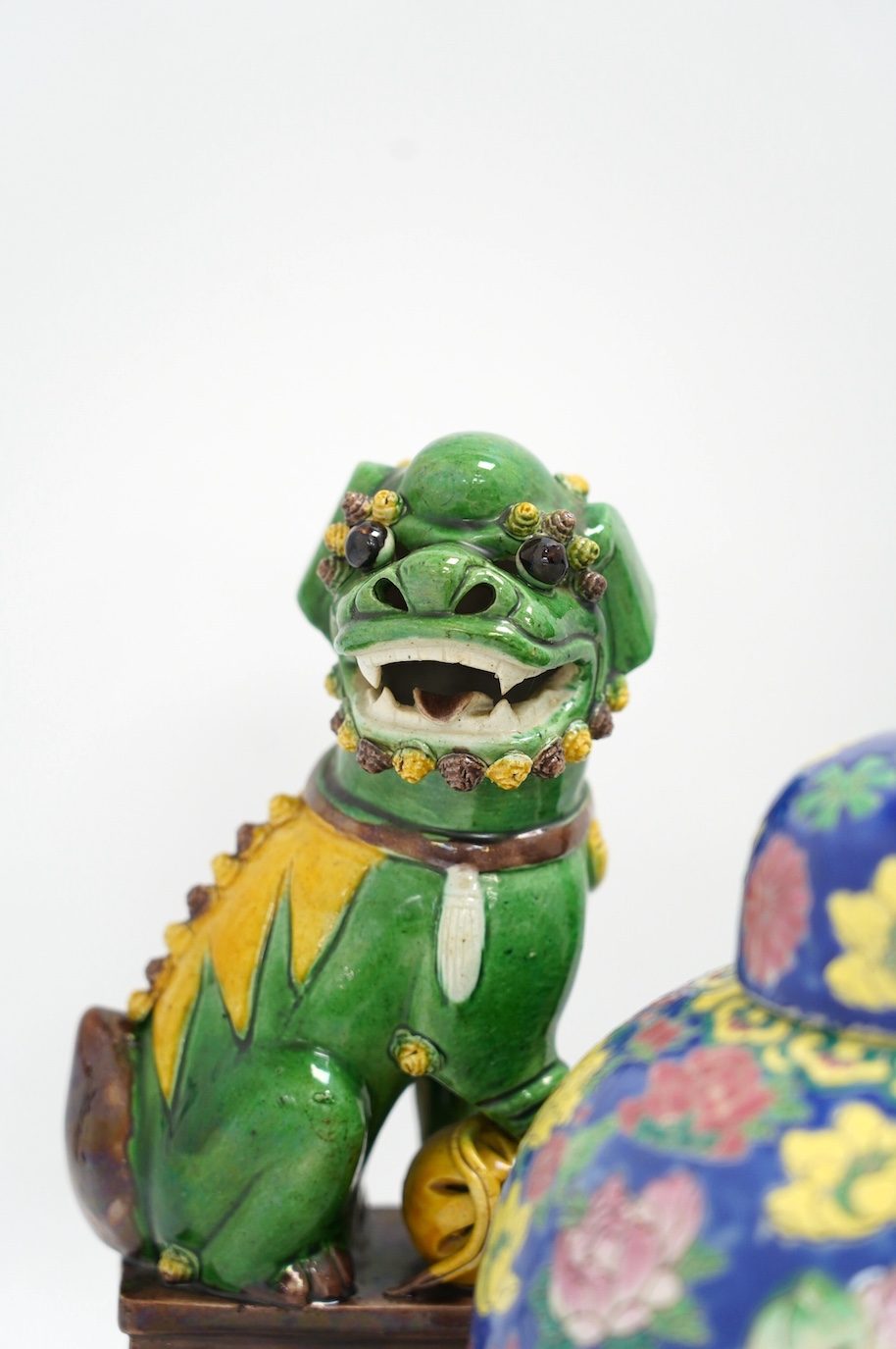 A pair of Chinese lion dogs and a floral enamelled jar and cover, largest 26cm high. Condition - good